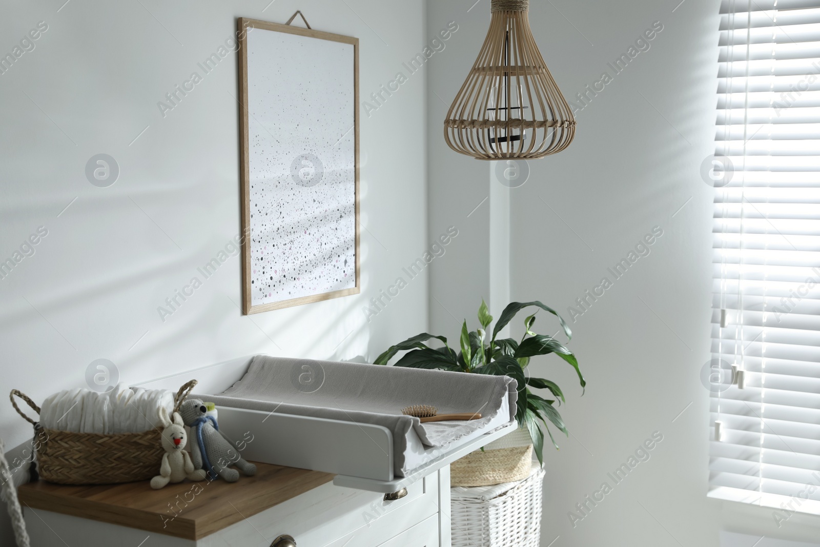 Photo of Chest of drawers with changing tray and pad in baby room. Interior design