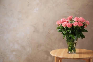 Vase with beautiful rose flowers on table