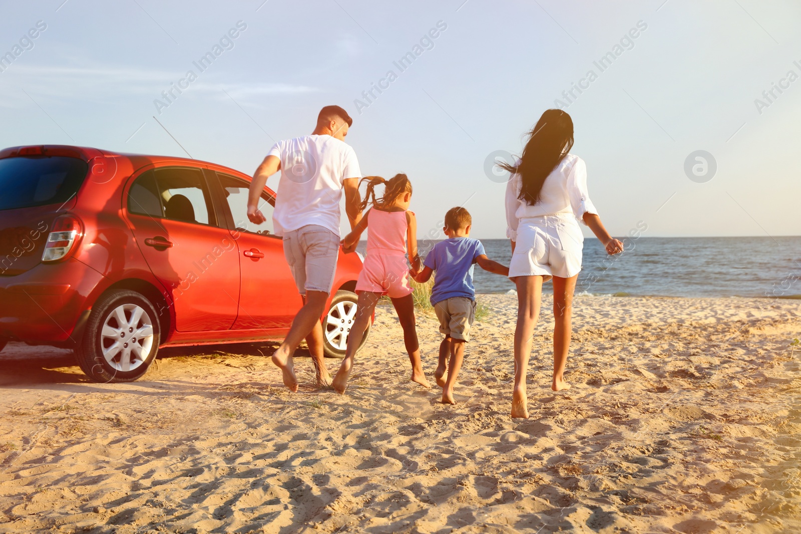 Photo of Family running on sandy beach. Summer trip