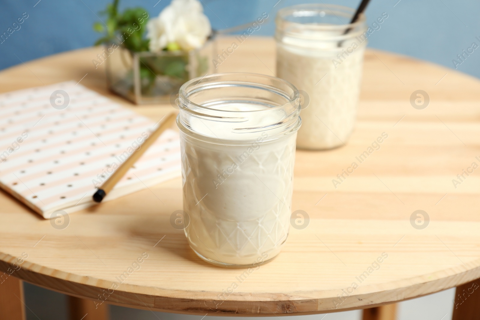 Photo of Jar with yummy yogurt on wooden table