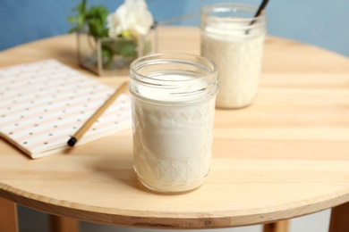 Photo of Jar with yummy yogurt on wooden table