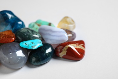 Pile of different beautiful gemstones on white background