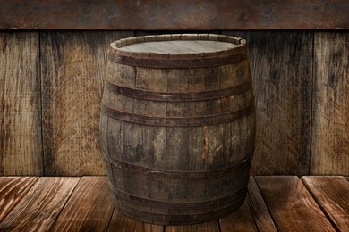 Image of One wooden barrel on brown surface near textured wall