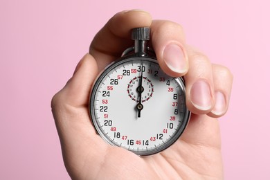 Photo of Woman holding vintage timer on pink background, closeup