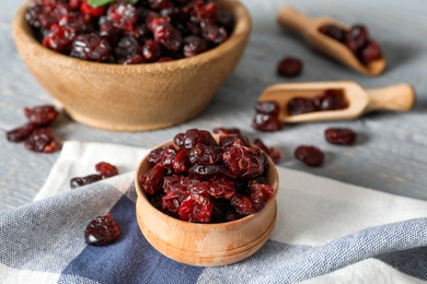 Photo of Tasty dried cranberries in wooden bowl on table