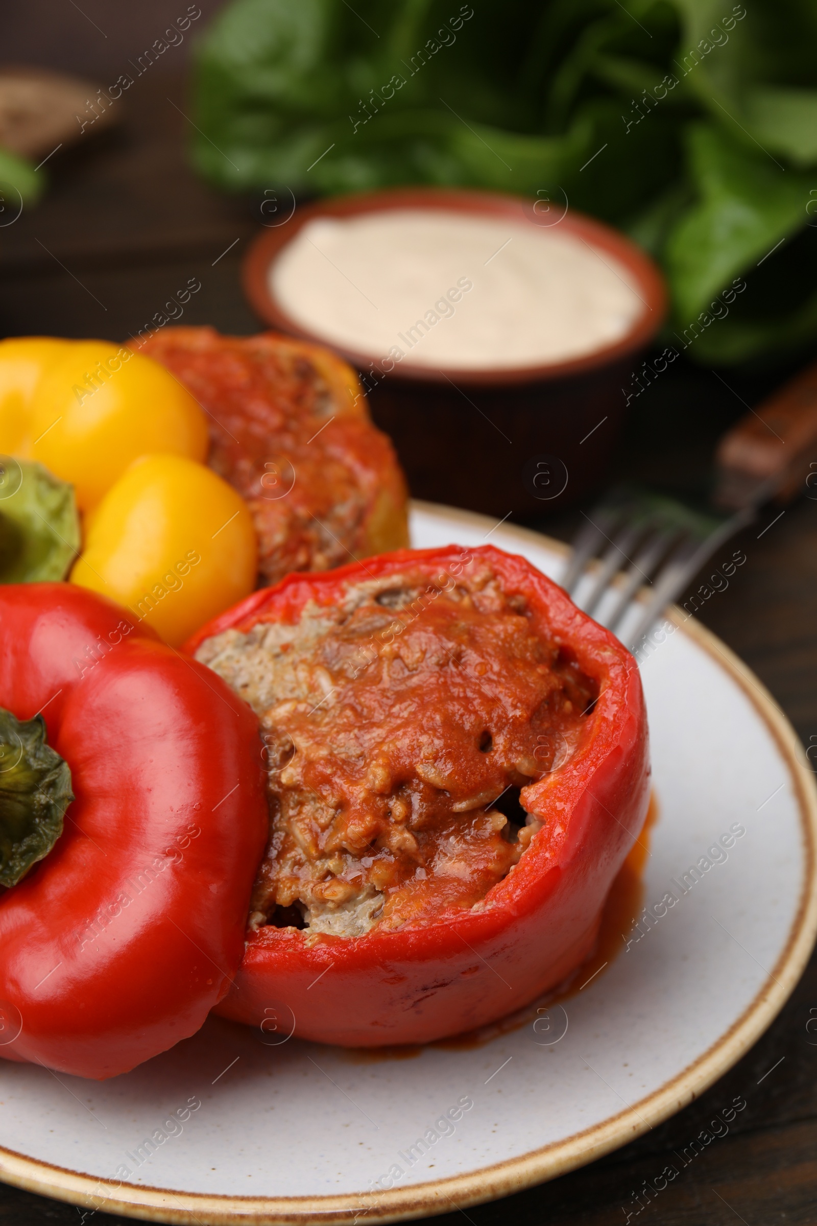 Photo of Delicious stuffed bell peppers served on wooden table, closeup