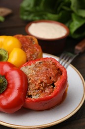 Photo of Delicious stuffed bell peppers served on wooden table, closeup