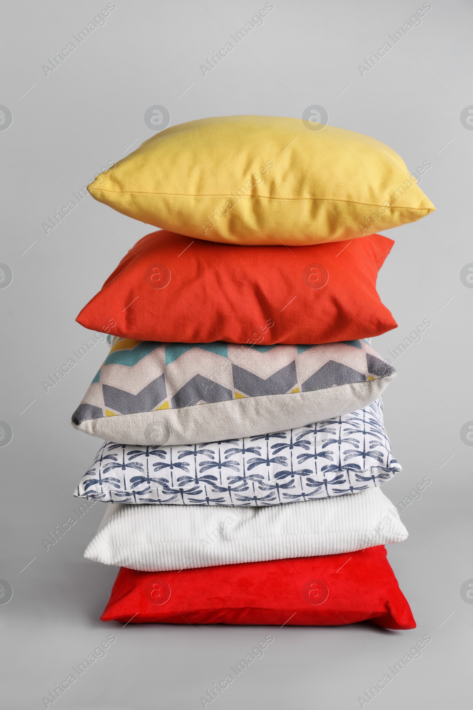 Photo of Stack of stylish soft pillows on grey background