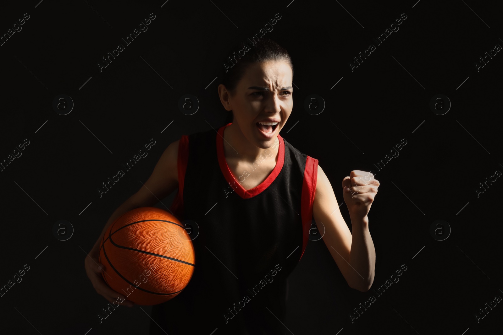 Photo of Basketball player with ball on black background