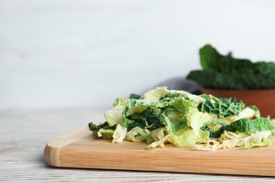 Cutting board with chopped savoy cabbage on table. Space for text