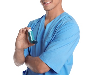 Male doctor holding asthma inhaler on white background, closeup. Medical object