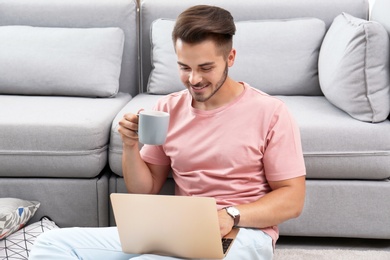 Man in casual clothes using laptop at home