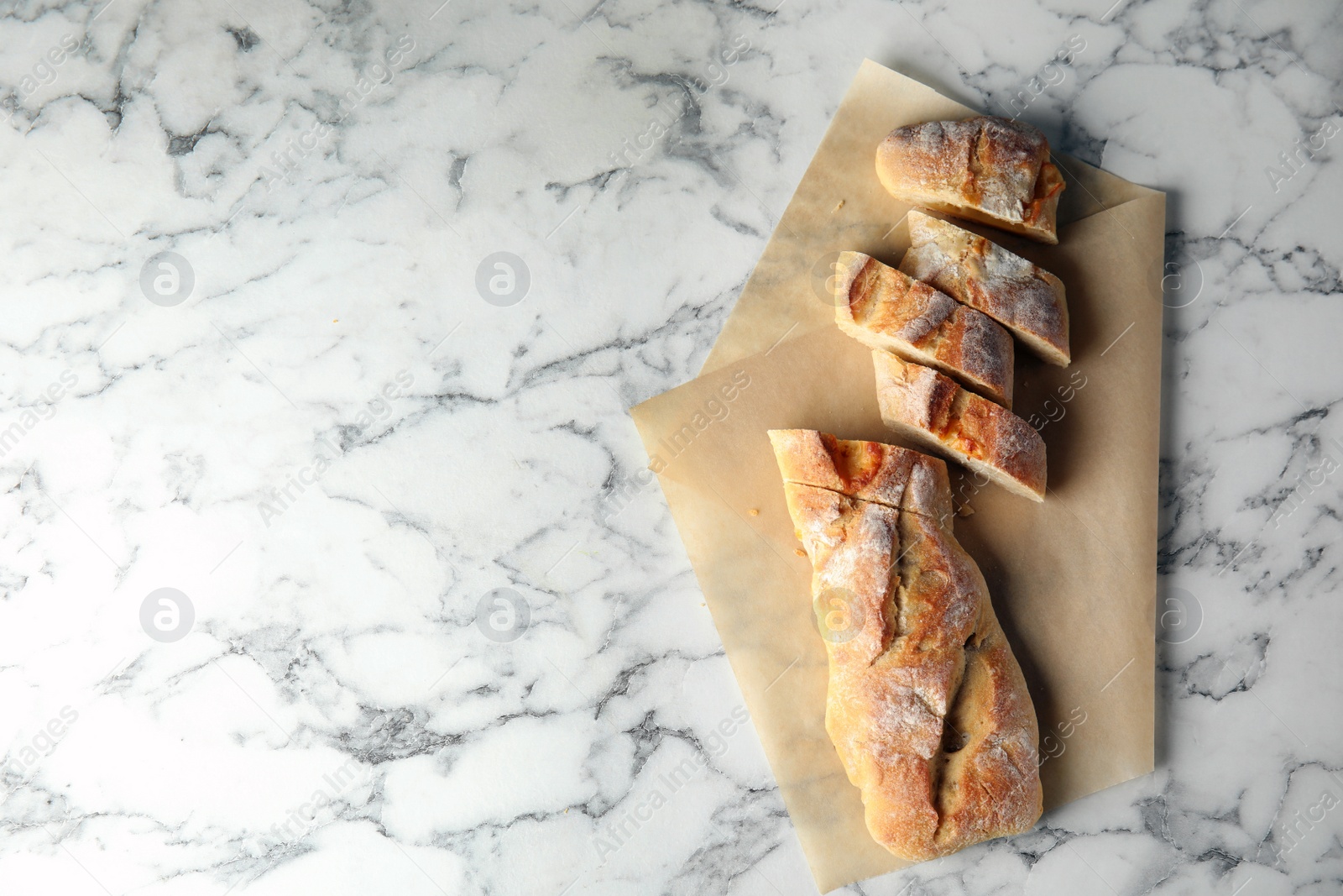 Photo of Tasty bread on marble background, top view. Space for text