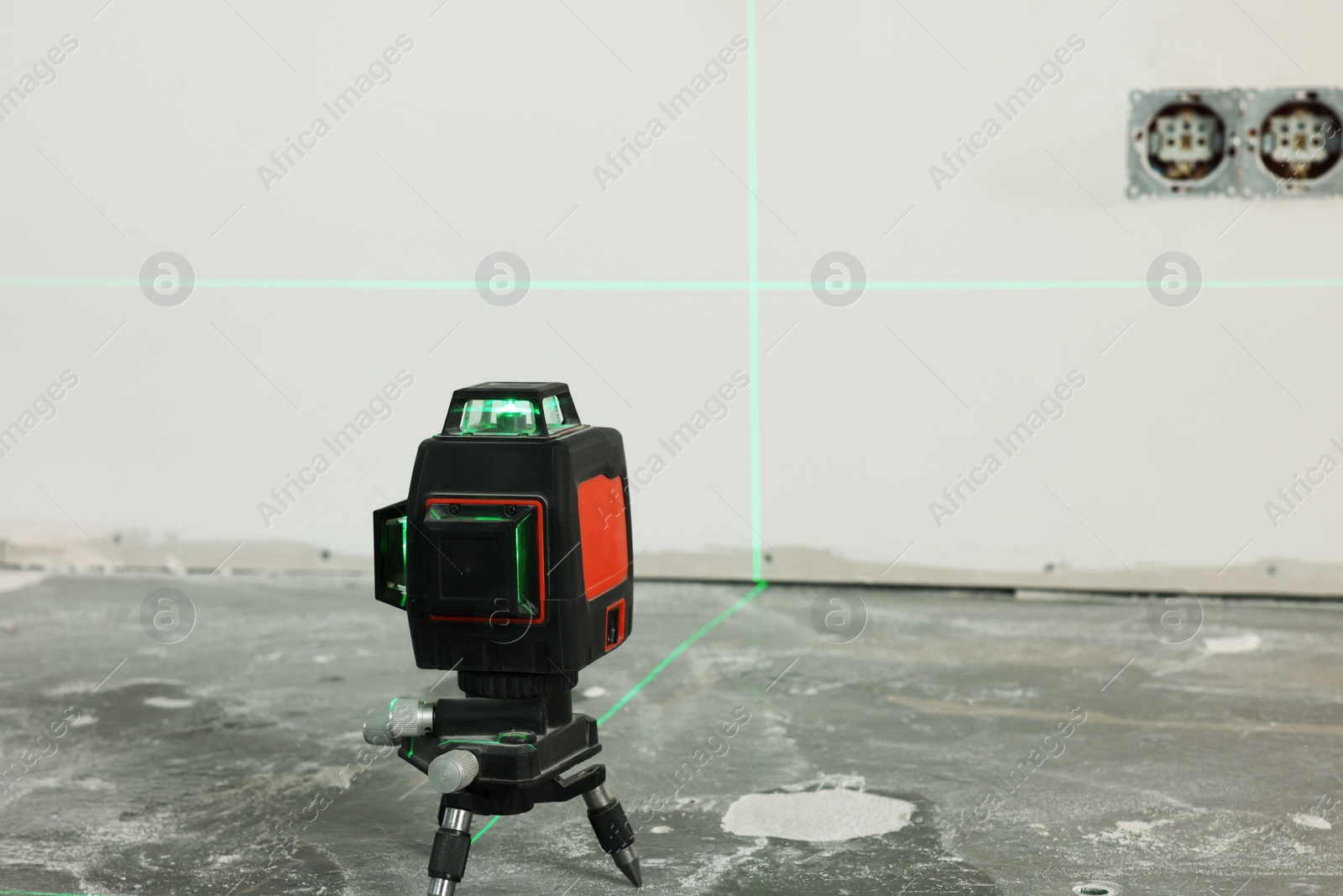 Photo of Laser level on floor near electrical sockets