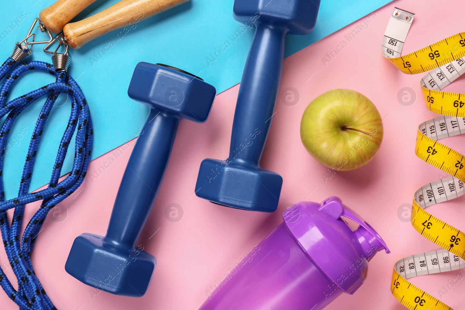 Photo of Flat lay composition with dumbbells on color background