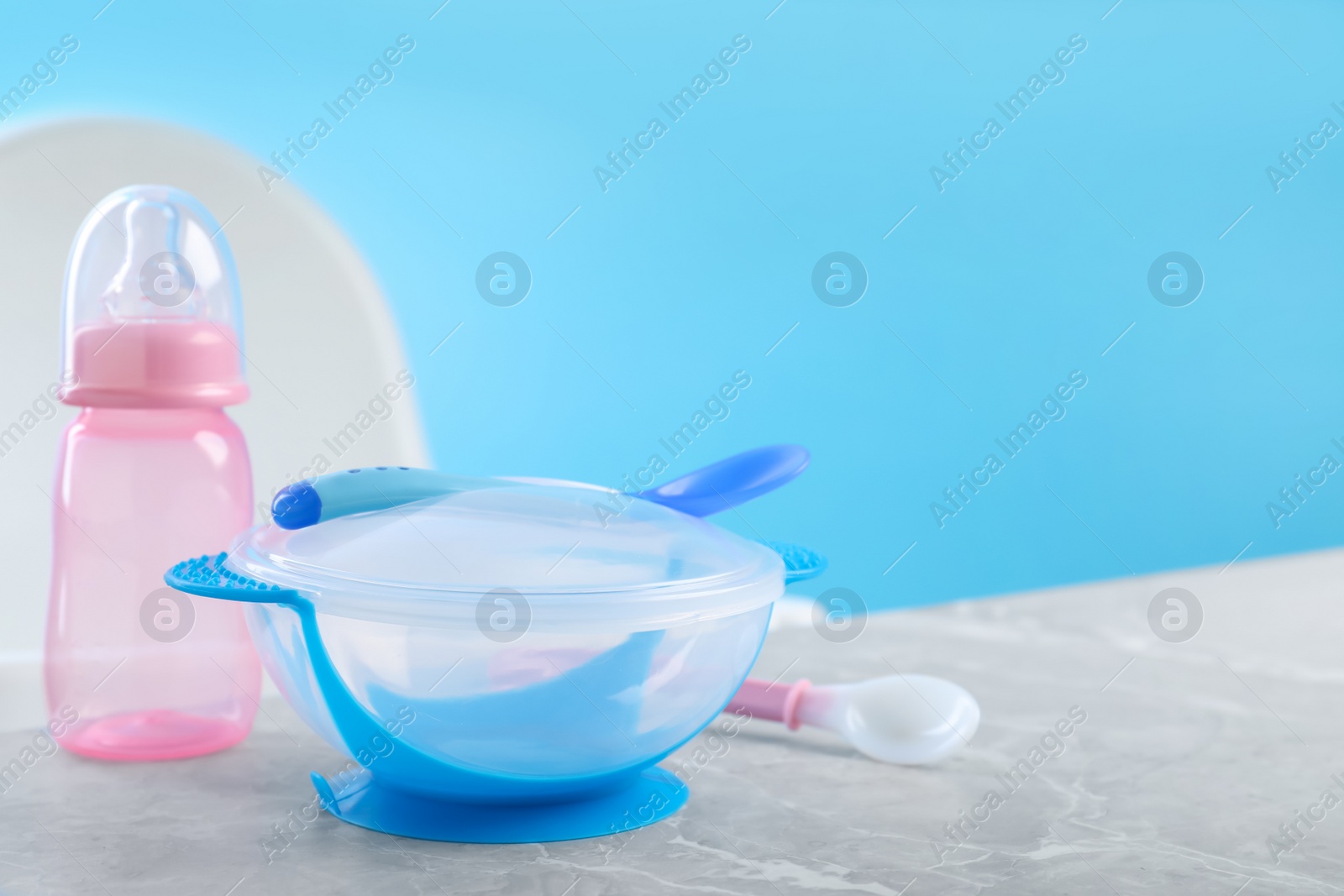 Photo of Set of plastic dishware on grey table. Serving baby food