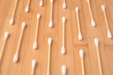 Many clean cotton buds on wooden table, above view