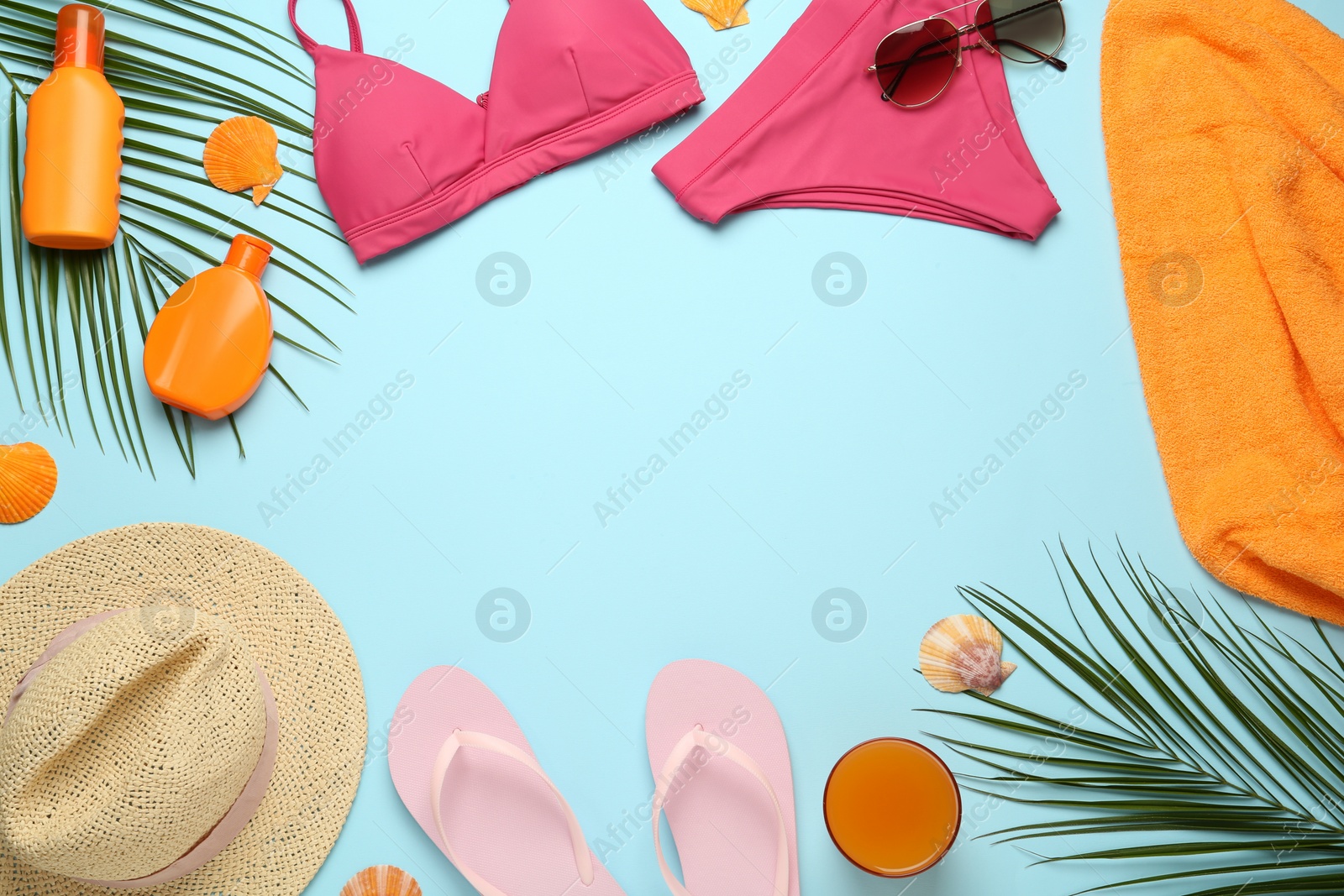 Photo of Frame made with different beach objects on light blue background, flat lay. Space for text