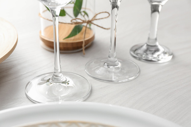 Photo of Glasses on white wooden table, closeup. Festive setting