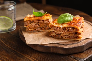 Photo of Delicious lasagna served on wooden table, closeup