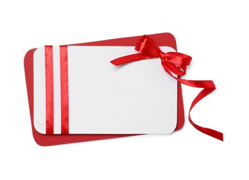 Photo of Blank gift card with red bow isolated on white, top view