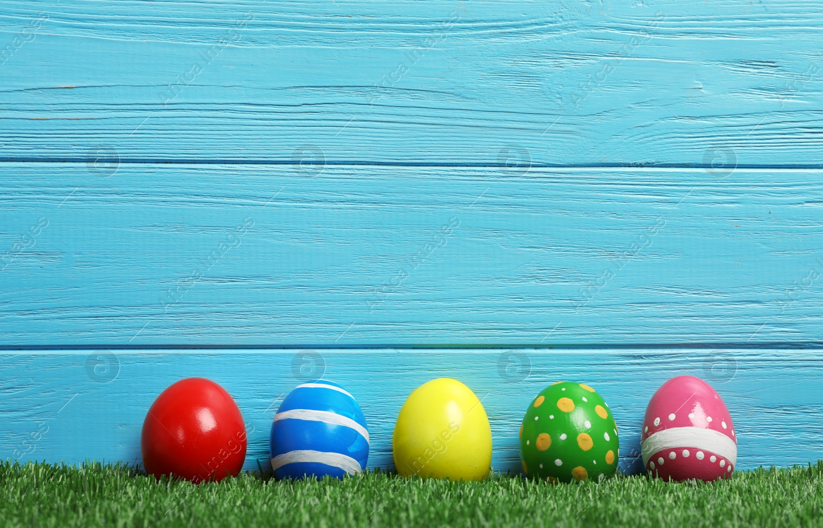 Photo of Decorated Easter eggs on green grass. Space for text