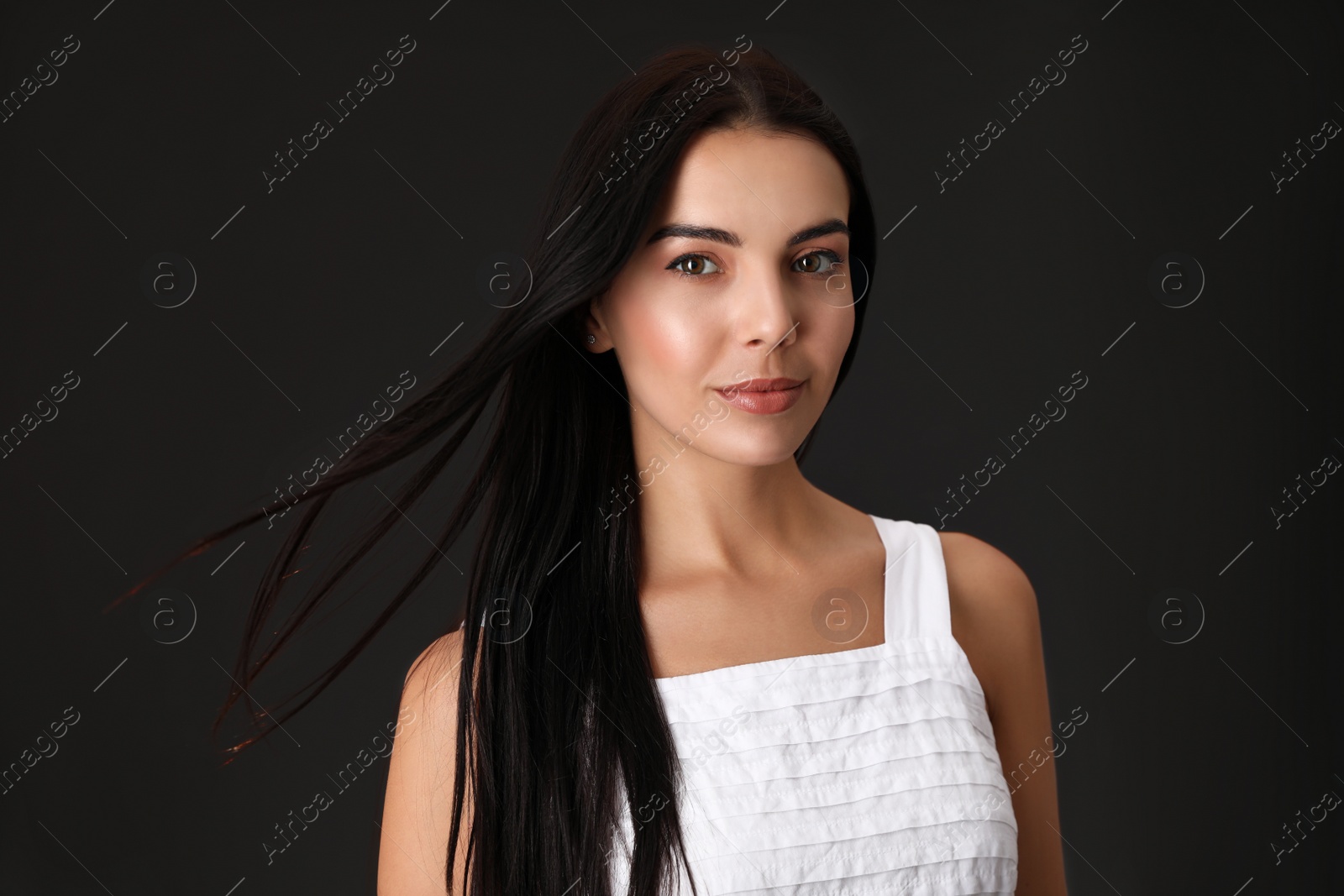 Photo of Portrait of beautiful young woman on dark grey background