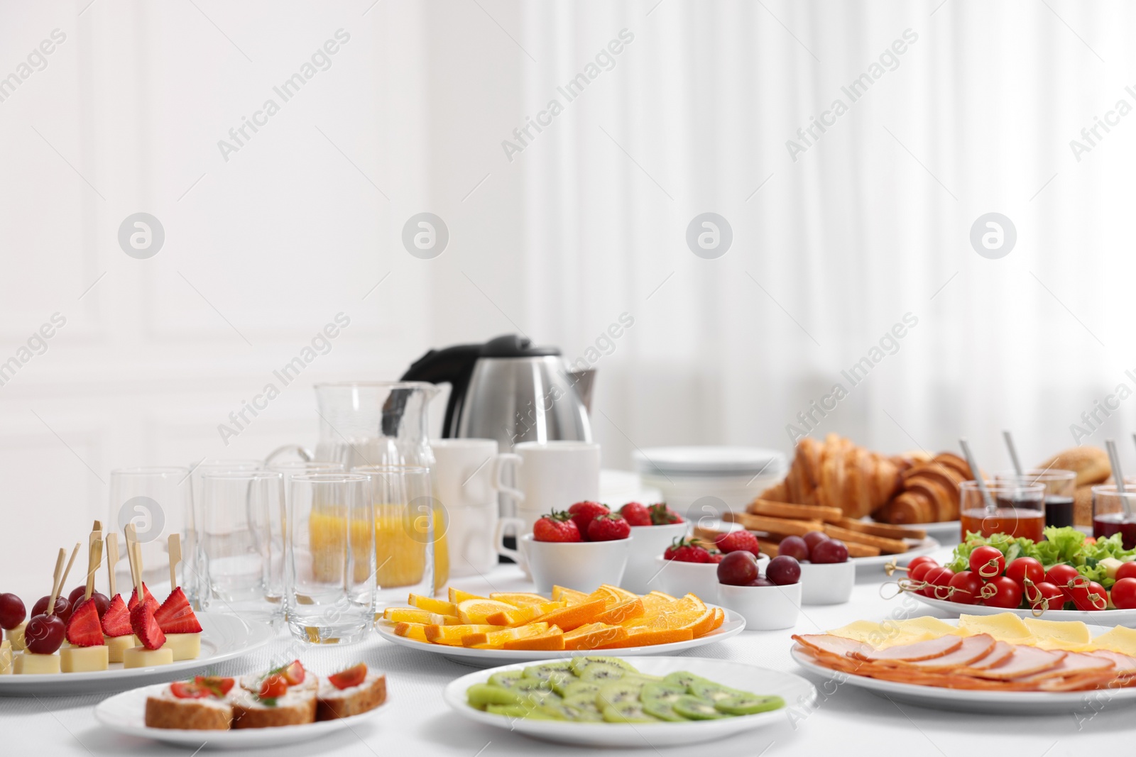 Photo of Different meals served on white table indoors. Buffet menu