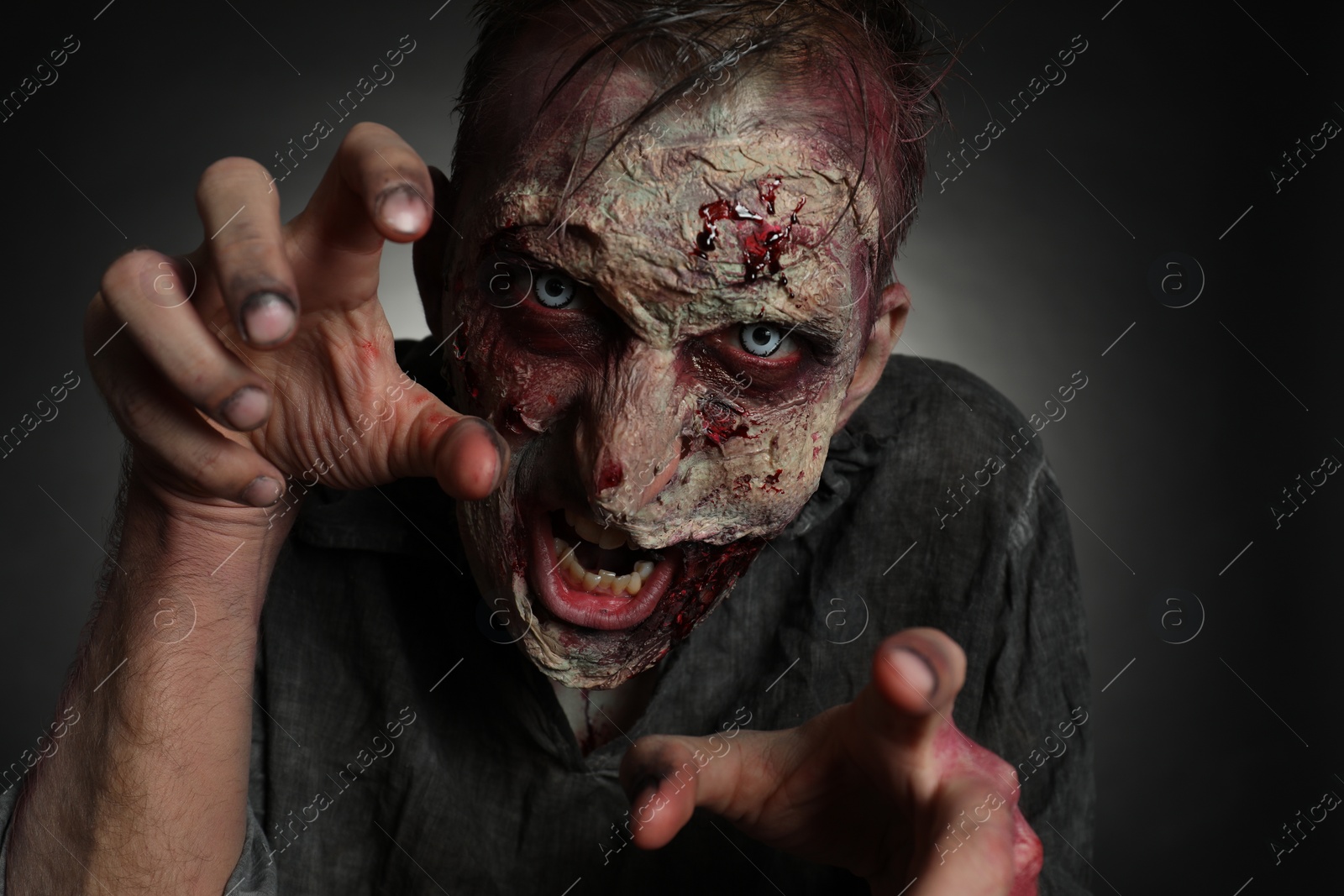 Photo of Scary zombie on dark background, closeup. Halloween monster