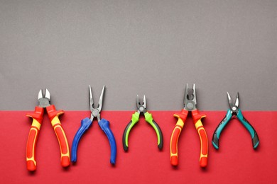 Photo of Different pliers on color background, flat lay. Space for text