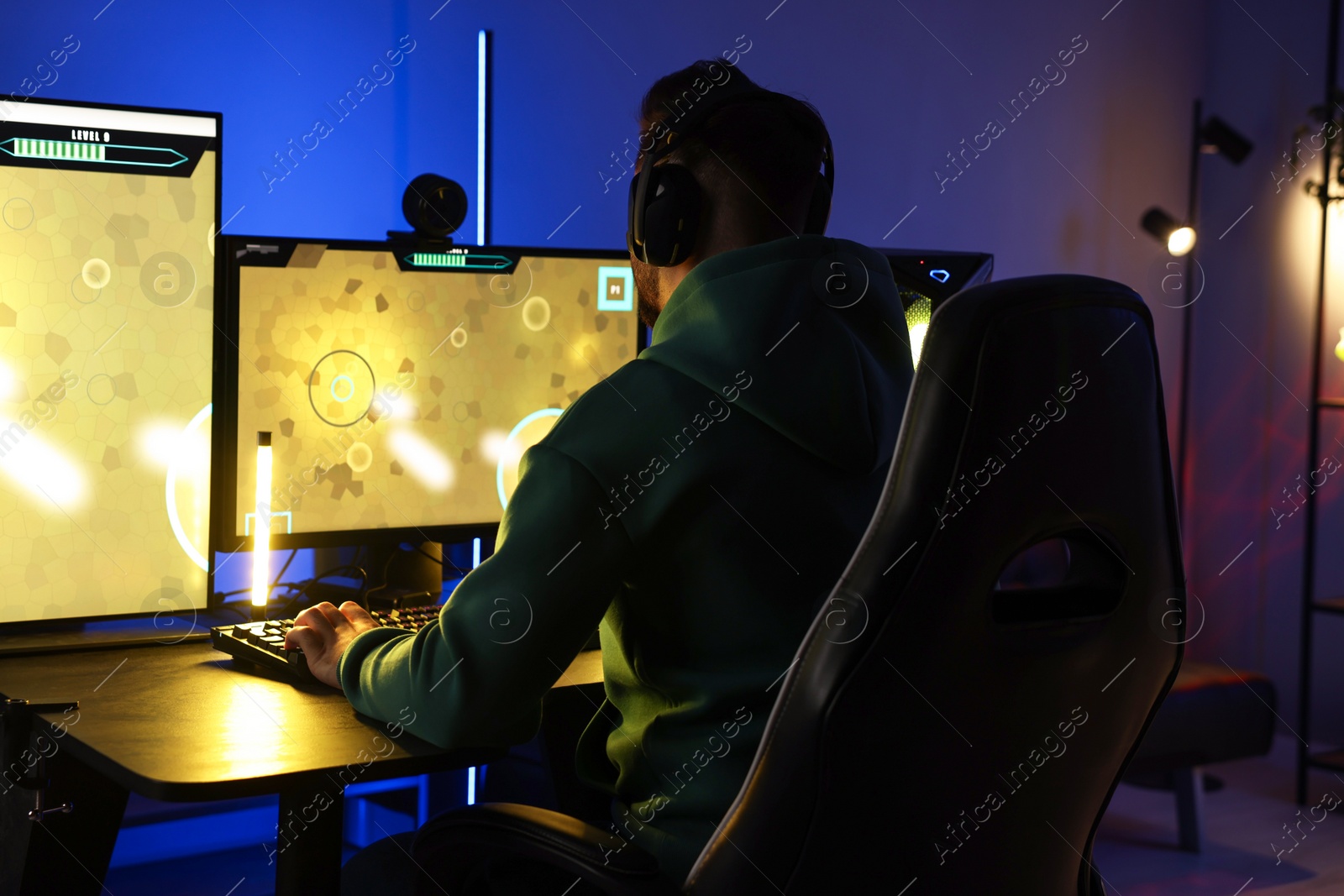 Photo of Man playing video games on computer at table indoors