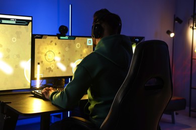 Photo of Man playing video games on computer at table indoors