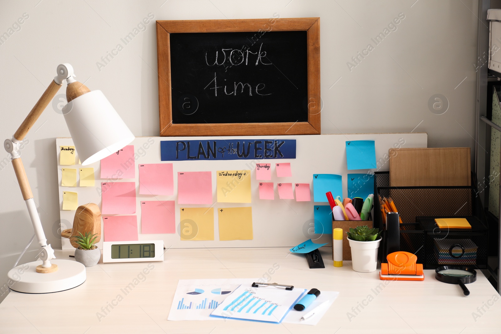 Photo of Business process planning and optimization. Workplace with lamp, colorful paper notes and other stationery on white wooden table