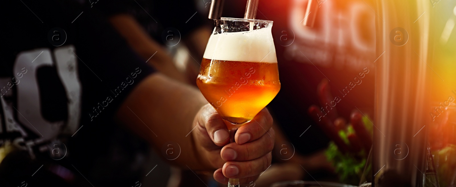 Image of Bartender pouring beer into glass in pub, closeup. Banner design