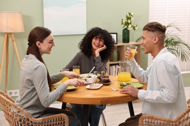 Happy friends having vegetarian meal in cafe