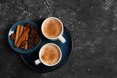 Photo of Delicious eggnog with anise and cinnamon on grey table, flat lay. Space for text