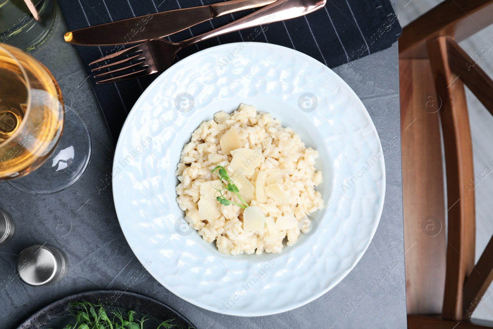 Photo of Delicious risotto with cheese on grey table, flat lay