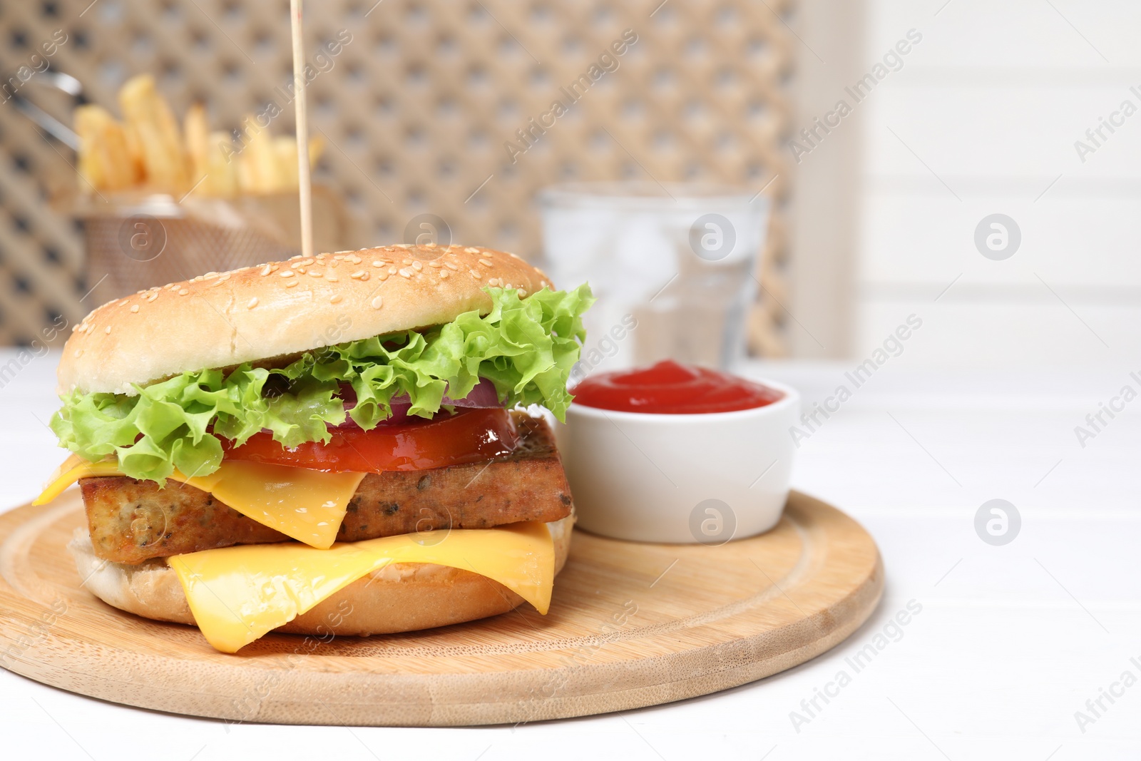 Photo of Delicious tofu burger served with sauce on white table. Space for text