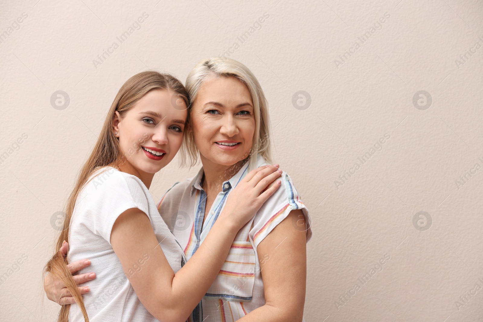 Photo of Mother and her adult daughter on beige background. Space for text