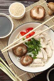 Delicious ramen with meat and ingredients on wooden table, flat lay. Noodle soup