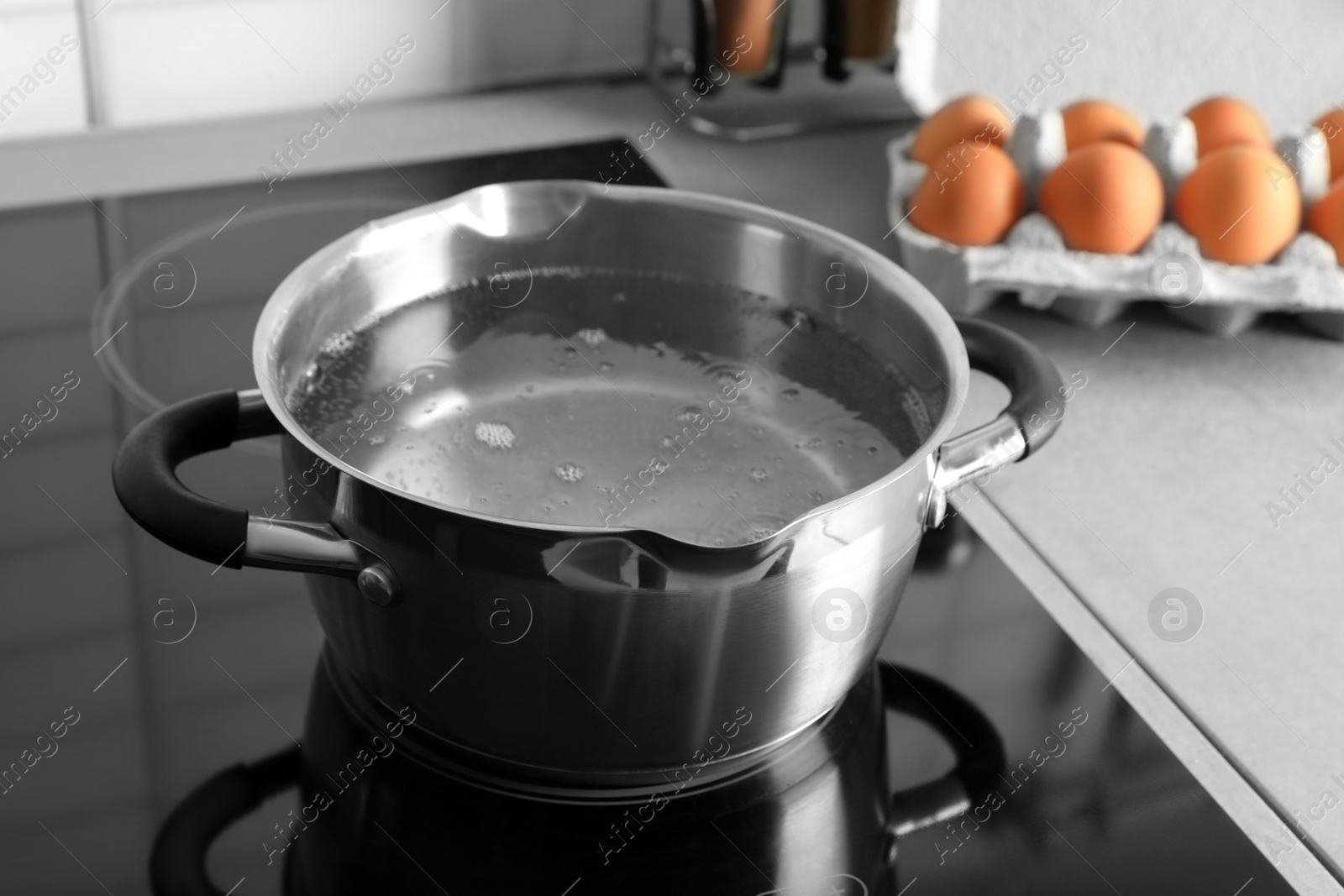 Photo of Pot with boiling water on electric stove in kitchen