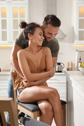 Photo of Lovely couple enjoying time together in kitchen at home