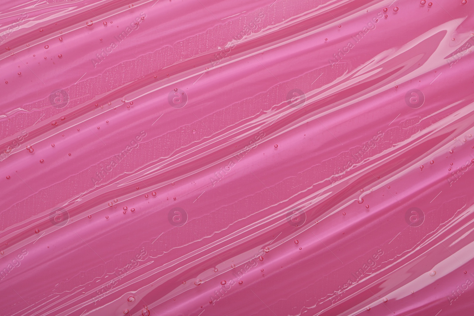 Photo of Pure transparent cosmetic gel on pink background, closeup