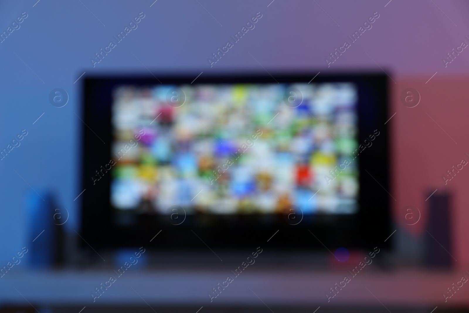 Photo of Blurred view of modern TV set on table indoors