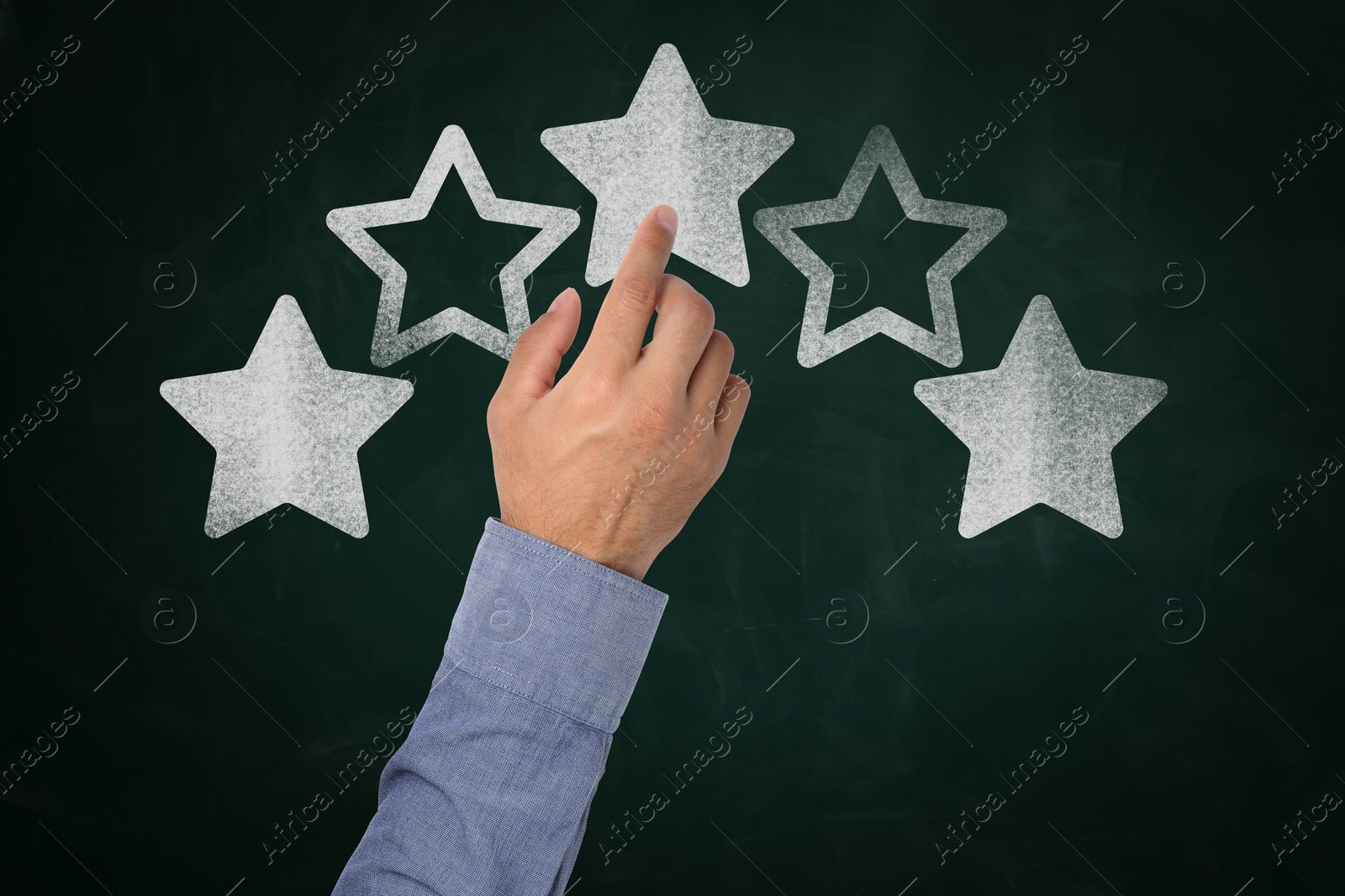 Image of Quality rating. Man pointing at stars on chalkboard, closeup