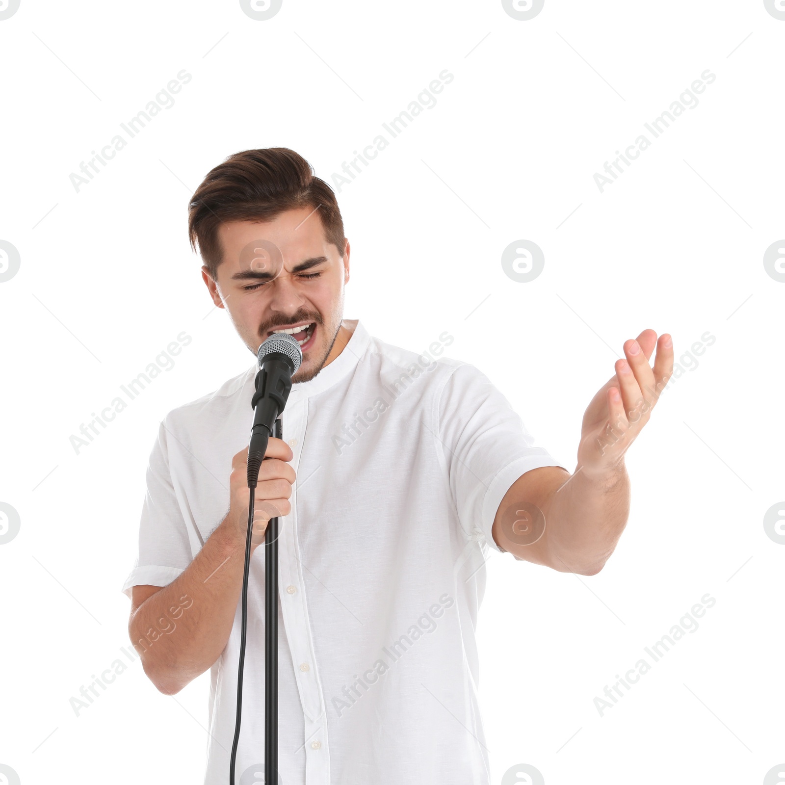 Photo of Young handsome man singing in microphone on white background