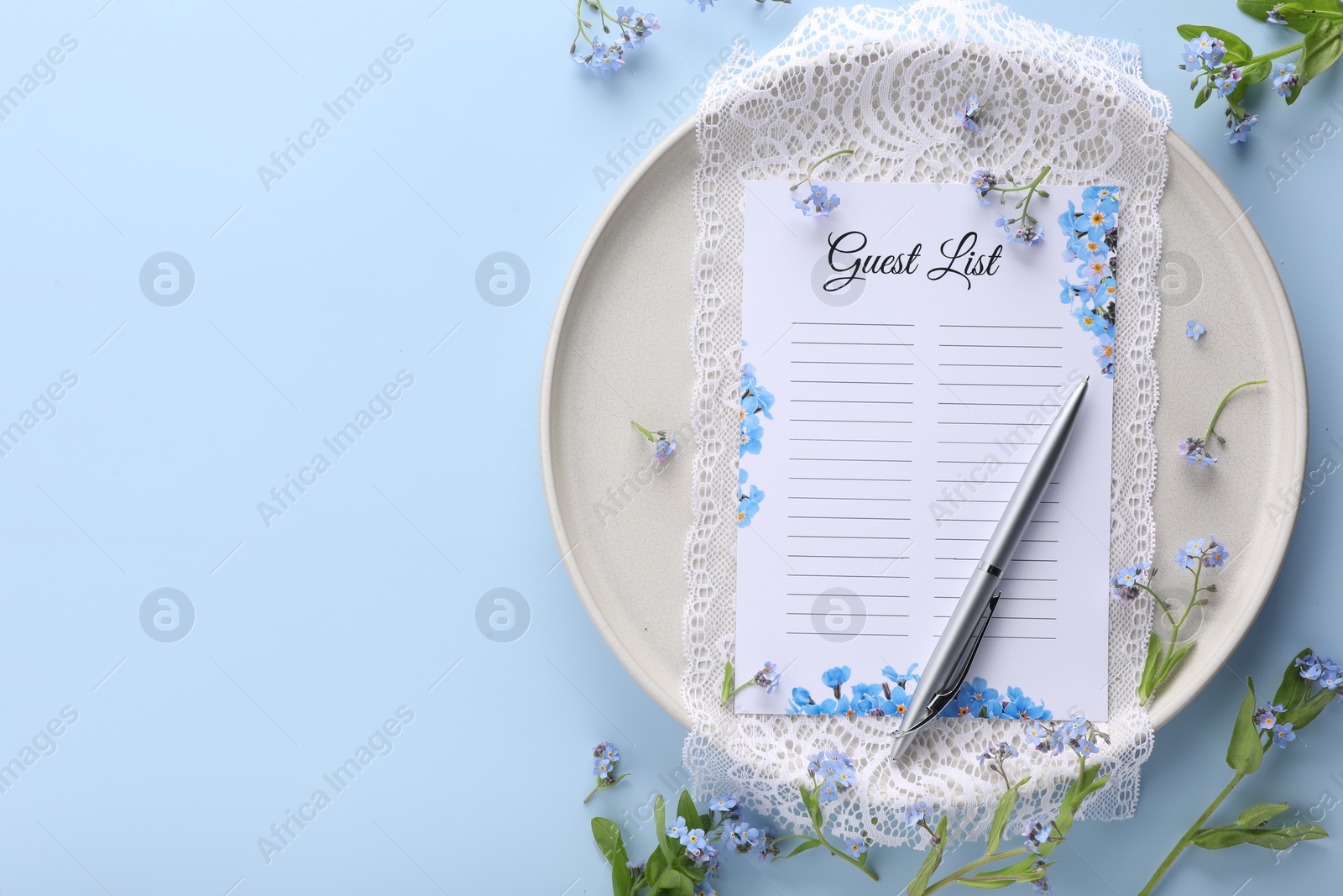 Photo of Plate with guest list, pen, lace and flowers on light blue background, flat lay. Space for text