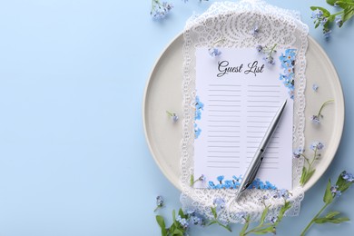 Plate with guest list, pen, lace and flowers on light blue background, flat lay. Space for text