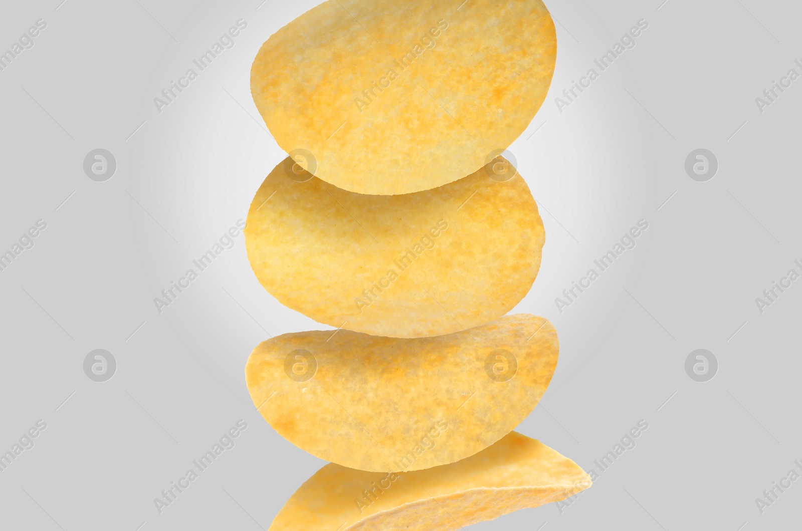 Image of Stack of tasty potato chips on light grey background