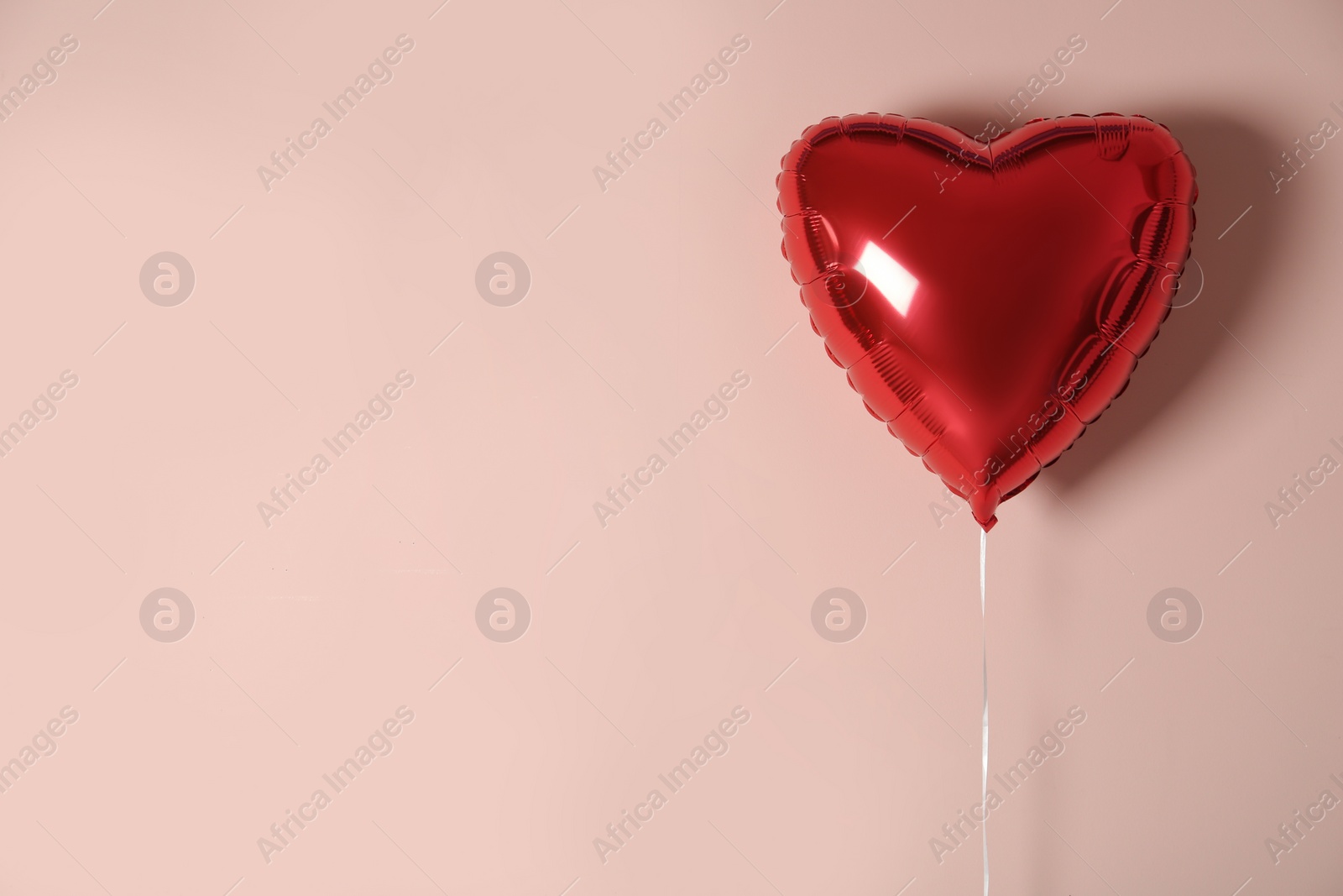 Photo of Red heart shaped balloon on pink background, space for text. Valentine's Day celebration